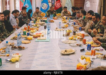 Top Berater von Task Force (Südwest) (TFSW) und der afghanischen nationalen Verteidigungs- und Sicherheitskräfte (ANDSF) teilen sich eine Mahlzeit zusammen nach einer Sicherheit Shura bei Bost Flugplatz, Afghanistan, Jan. 25, 2018. Top Berater aus TFSW und führenden Persönlichkeiten aus dem ANDSF kamen zusammen, um zu diskutieren, zu Aktionen für den Betrieb Maiwand 11. Sie erörterten ferner die vorläufigen Sicherheitslösungen weitere Stärkung der Helmand Sicherheit und Stabilität in der Region. Stockfoto