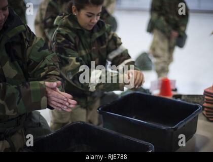 Flieger mit der 49 Bauingenieur Squadron Praxis richtige Händewaschen Verfahren auf eine Zone Übergang Ausbildung Station während eines Versuches Fähigkeit, zu überleben und zu bedienen Rodeo Holloman Air Force Base, N.M., Jan. 11, 2018. Das Rodeo hilft Flieger für unvorhergesehene Ereignisse mit chemischen, biologischen, radiologischen und nuklearen Angriffen durch Stärkung ihrer grundlegenden Kriegsführung überleben und operative Fähigkeiten vorbereiten. Dozenten aus der 49. CES verarbeitet mehr als 200 Flieger durch die atso Rodeo pro Monat für die nächsten sechs Monate. Stockfoto