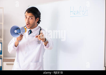 Junger Arzt vor der Tafel Stockfoto