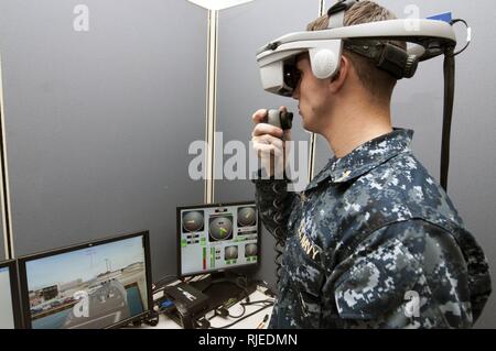 NORFOLK, Virginia (Nov. 16, 2012), der Stern Ryan Landeen trägt ein conning Officer virtuelle Umgebung (COVE) Headset, als er einem virtuellen Schiff während einer Übung während des Basic Division Officer Kurs navigiert. Der Kurs, an der Oberfläche Warfare Officer Schule gibt neu in Betrieb genommene Fähnriche die Grundlagen und Fähigkeiten für eine Division Officer - auf See erforderlich. Stockfoto