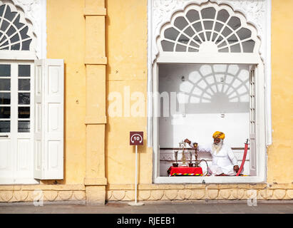 JODHPUR, Rajasthan, Indien - MÄRZ 08, 2015: Rajasthan alter Mann mit weissen Bart in der Nähe von Shisha und andere traditionelle Symbole des königlichen Lebens in Mehrangarh f Stockfoto