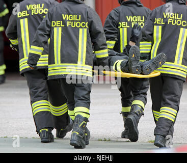 Vicenza, VI, Italien - 10. Mai 2018: Italienische Bahre träger Feuerwehrleute transport einer auf der Bahre während einer praktischen Roadside Rescue Übung verletzt Stockfoto