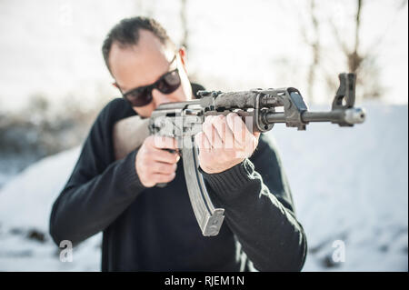 Vorderansicht gun Punkt der riffle Maschinengewehr. Waffe schießen und Waffen Training. Winter schnee Hintergrund auf outdoor Schießstand Stockfoto