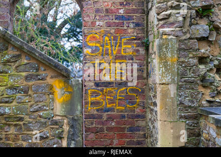 Speichern Sie die Bienen Graffiti und Emblem scrawled auf einer alten Mauer, Großbritannien Stockfoto