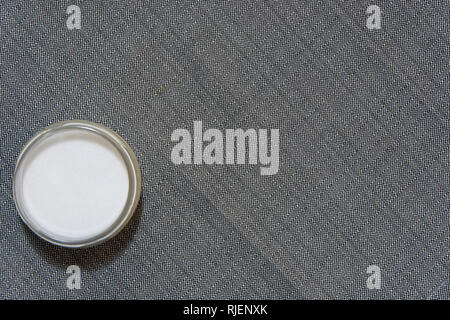Ein Glas Salz mit grauen Texturen Hintergrund Stockfoto