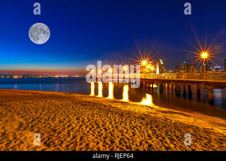 Schöne Nacht mit Vollmond am Fähranleger in Coronado Coronado Island, Kalifornien, USA. Die Innenstadt von San Diego für den Hintergrund. Alte hölzerne Pier Stockfoto