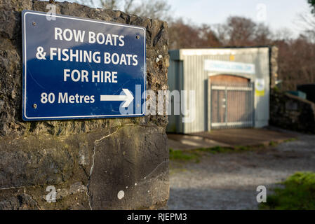 "Boote zum Vermieten" -Schild. Am Pier im Killarney National Park, County Kerry, Irland, stehen Ruderboote und Angelboote zum Verleih Stockfoto