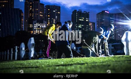 Die einheimischen Arbeiter mit der American Battle Monuments Kommission mit Mitgliedern der Verteidigung POW/MIA Accounting Agentur (DPAA) während einer disinterment im Manila American Cemetery in Manila, Philippinen, Jan. 22, 2018. Die DPAA disinterment war Teil der Anstrengungen, um die unbekannten während des Zweiten Weltkriegs verloren zu identifizieren und die möglichst vollständige Buchhaltung unserer fehlt Personal zu ihren Familien und der Nation. Stockfoto