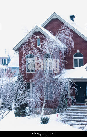Montreal, Quebec, Kanada, Februar 2019 - Brick House im Winter und Bäume nach einem Eissturm Stockfoto