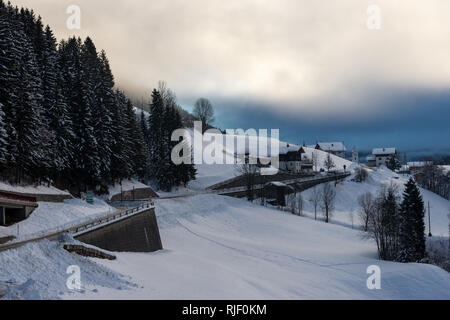 Dorf in den Alpen unter dunklen Wolken Stockfoto
