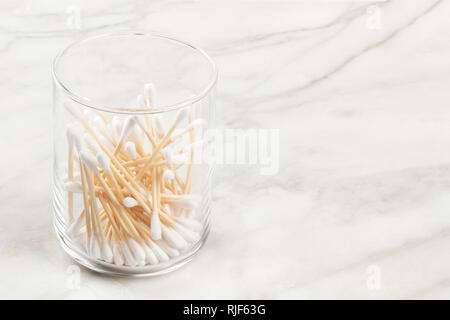 Bambus Wattestäbchen in einem Glas auf einem Marmor Oberfläche mit Kopie Raum Stockfoto