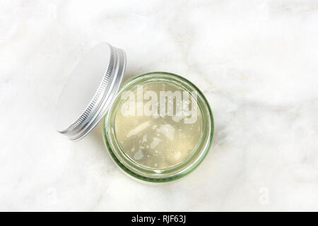 Ein Glas Glas mit Aloe vera Gel, Schuß von oben auf weißem Marmor Hintergrund mit einem Platz für Text Stockfoto