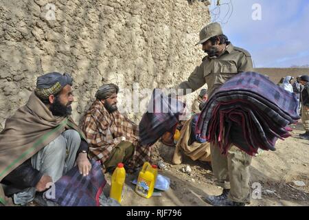 Afghanische Polizei decken und andere humanitäre Hilfe die Versorgung der Dorfbewohner verteilen in Shah Freude Bezirk, Zabul Province, Afghanistan, 31.01.16. Die ALP ist eine defensive, Community-orientierte Kraft, bringt Sicherheit und Stabilität in den ländlichen Gebieten Afghanistans. Stockfoto