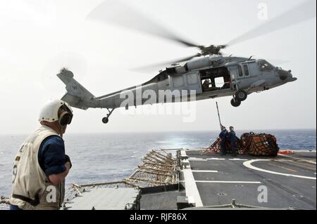 Mittelmeer (15. März 2013) Einem MH-60S Sea Hawk Hubschrauber die Ladegeräte der Hubschrauber bekämpfen Meer Squadron (HSC) 26 Tropfen liefert auf dem Flugdeck der geführten-missile Cruiser USS Stadt Hue (CG66) während einer Auffüllung zugewiesen-auf-See. Stadt Hue ist in die USA 5 Flotte Verantwortungsbereich Durchführung Maritime Security Operations eingesetzt, Theater Sicherheit Bemühungen um Zusammenarbeit und Unterstützung von Missionen im Rahmen der Operation Enduring Freedom. Stockfoto