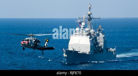 Arabische Meer (Nov. 8, 2012) Eine MH-60S Sea Hawk Helikopter von Eightballers der Hubschrauber Meer Combat Squadron (HSC) 8 fliegt vorbei geführte-missile Cruiser USS Mobile Bay (CG53) während einer Auffüllung-auf-See mit dem Militär Sealift Command schnell Combat support ship USNS Brücke (T-AOE 10). Mobile Bay, auf die John C Stennis Streik Gruppe zugeordnet ist, wird in den USA 5 Flotte Verantwortungsbereich Durchführung Maritime Security Operations eingesetzt, Theater Sicherheit Bemühungen um Zusammenarbeit und Unterstützung für die Operation Enduring Freedom. Stockfoto