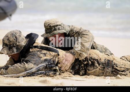 Explosive Ordnance Disposal 1. Klasse Joseph Tumminello von Oak Ridge, Tennessee, Mitglied des Naval Surface Warfare Center, Indian Head Explosive Ordnance Entsorgung Unternehmensbereich Technologie (NSWC IHEODTD), reibt Sand auf der Uniform der Marine Sgt. Christian Jardine von San Diego, ein Telefon-Funker mit 4. Force Reconnaissance Company, 2nd Platoon, während eine amphibische Einfügung Bohrer beim Marine Corps Training Bereich Balg Aug. 18 , 2014. Tumminello war Teil eines vierköpfigen Navy Taucher und Abriss Teams erweitern die 4. Reconnaissance Company Marines während einer zweiwöchigen jährlichen Trainingsperiode Stockfoto