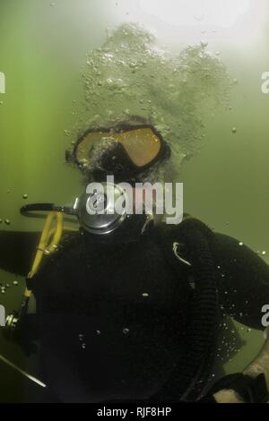 Marine Diver 1. Klasse Wade Luoma, für die Beseitigung von Explosivstoffen Mobile Einheit (EODMU) 11, 11-7, an die Oberfläche steigt nach einer Anti-terror-Force Protection dive zugeordnet. EODMU 11 ist an Commander, Task Group 56.1 zugewiesen, die Förderung der Mine Gegenmaßnahmen, die Beseitigung von Explosivstoffen, bergung Tauchen, und Schutz für die USA 5 Flotte Verantwortungsbereich. Stockfoto