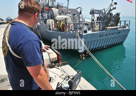 MINA SALMAN PIER, Bahrain (2. April 2013) Navy Diver 1. Klasse James Goodman, auf Mobile Tauchen und Bergung (MDSU) 2, 2-2, mit seinem Taucher spricht während der Überwachung eine Propeller-inspektion Dive zugeordnet. MDSU 2 ist es, Commander, Task Group 56.1 zugewiesen und bietet retten, Tauchen, Terrorismusbekämpfung und Schutz für die USA 5 Flotte Verantwortungsbereich. Stockfoto