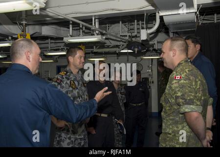 Chef Hospital Corpsman Curtis Stoughton führt das medizinische Team um Commodore Peter Leahy von der Royal Australian Navy, Kommandant der kombiniert Task Force (CTF) 176, während einer medizinischen Tour an Bord der amphibischen Angriff Schiff USS Peleliu (LHA-5) während der Rand des Pazifik (RIMPAC) Übung 2014.  Zweiundzwanzig Nationen, 49 Schiffe und sechs u-Boote, mehr als 200 Flugzeugen und 25.000 Mitarbeiter beteiligen sich an RIMPAC Übung vom 26. Juni bis Aug. 1, in und um die Inseln von Hawaii und Südkalifornien. Der weltweit größte internationale maritime Übung RIMPAC bietet eine einzigartige Ausbildung opp Stockfoto