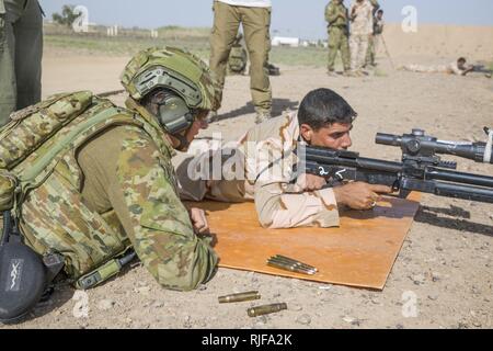 Eine australische Armee Trainer, mit Task Group Taji, Trainer ein irakischer Soldat feuerte. 50-Kaliber Gewehr, während der erweiterte Treffsicherheit Kurs im Camp Taji, Irak, 12. Juni 2018. Die irakischen Sicherheitskräfte sind das Fundament für die Zukunft des Irak durch die Verbesserung ihrer Fähigkeiten, um ein sicheres und stabiles Umfeld für ihre Nation zu stellen. Stockfoto