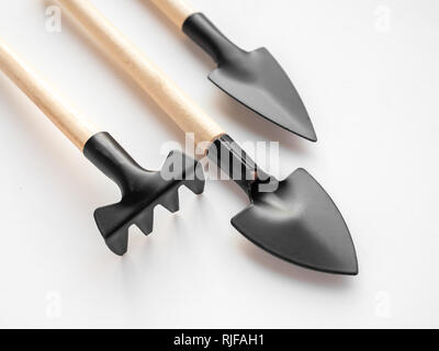 Close-up mini Garten Tool Set auf weißem Hintergrund. Drei Stück Garten Werkzeuge, Landwirtschaft Konzept. Stockfoto