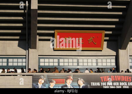Blick auf die Seite der Budokan Indoor Arena, wo die Leute in der Schlange warten, um ein Rockkonzert zu geben. Stockfoto