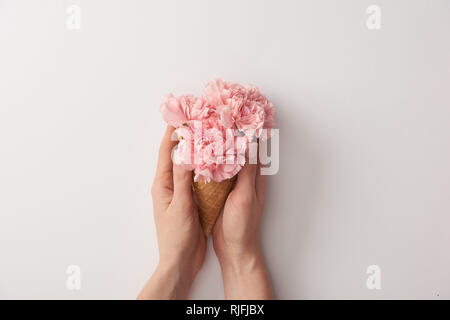 7/8 Schuß von Frau mit wafer Kegel mit schöne zarte Blumen isoliert auf Grau Stockfoto