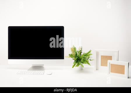 Arbeitsplatz mit Anlage, Bilderrahmen und desktop computer mit Kopie Raum isoliert auf weißem Stockfoto