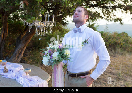 Attraktive Bräutigam freut sich auf das Aussehen der Braut Stockfoto