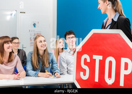 Fahrlehrer Holding theoretischen Teil der Fahrstunden mit STOP-Schild in der Hand. Stockfoto