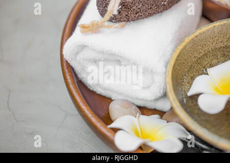 Spa noch Leben mit Baumwolle Handtuch, frangipani Blüten, Massage Steine in Holz- fach, selektiver Fokus, Wellness Produkte Details noch leben, Wellness backgr Stockfoto