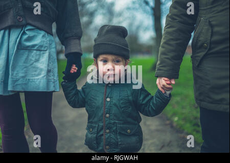 Ein kleines Kind zu Fuß, im Freien in einem Park mit seiner Mutter und Großmutter Stockfoto