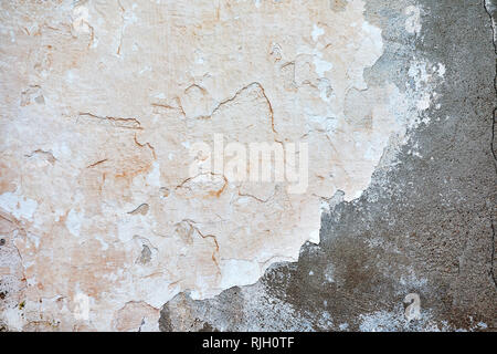 Pastell beige gefärbt, dreckig, alt und Risse verputzt grunge Wand mit abblätternder Farbe Flocken. Hintergrundbild. Stockfoto