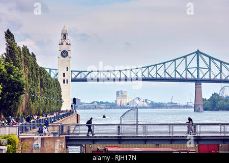 Montreal, Kanada - Juni, 2018: Der Uhrturm und Jacques Cartier Brücke über den Sankt-Lorenz-Strom im Alten Hafen von Montreal, Quebec, Kanada. Editorial. Stockfoto