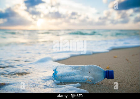 Verwendete Kunststoff Flasche Wasser gewaschen, am Ufer eines tropischen Strand, wobei die weltweite Krise aus Kunststoff die Verschmutzung selbst auf abgelegenen Inseln Stockfoto