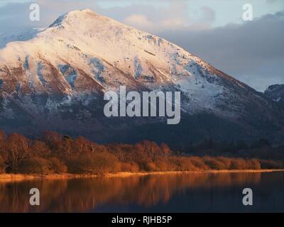 Die schneebedeckten Ullock Pike, beleuchtet von der untergehenden Sonne, Bassenthwaite Lake, Lake District National Park, Cumbria, England, Vereinigtes Königreich Stockfoto