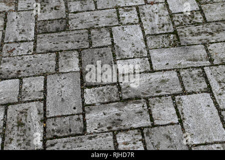 Bürgersteig, Auffahrt, Pflastersteine, Pflaster. Perspektivische Ansicht von monotonen grauen Stein Stein auf den Boden für die Straße Straße. Stockfoto