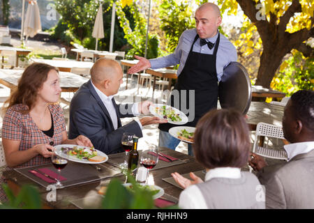 Konflikt zwischen Kellner und Client im open-air Restaurant Stockfoto