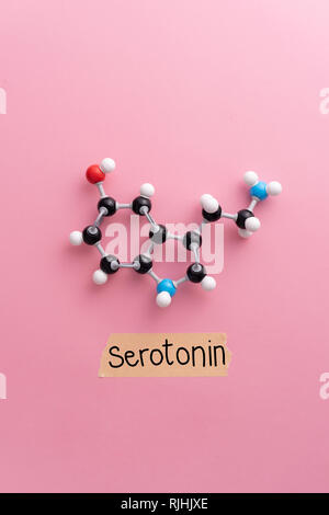 Serotonin chemische Formel mit der erotonin' handschriftliche Text über rosa Hintergrund Stockfoto