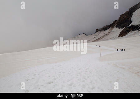 Spaziergang durch den Schnee in die Jungfrau Region, Tag mit vielen Wolken, die den Blick auf den höchsten Berg Europas der Jungfrau behindern Stockfoto