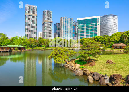 Hamarikyu mit Gebäuden am Teich von Shiodome-Shimbashi Bezirk auf Hintergrund reflektieren. Hama-rikyu ist eine große schöne Landschaft Garten in Stockfoto