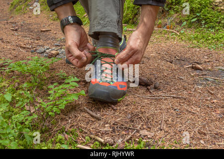 Befestigung ihre Schuhe in einem Wald Stockfoto