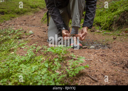 Befestigung ihre Schuhe in einem Wald Stockfoto