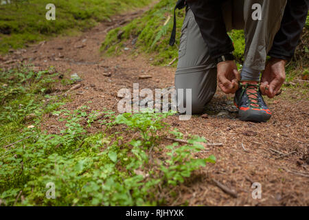 Befestigung ihre Schuhe in einem Wald Stockfoto