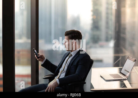 Geschäftsmann mit im Büro hochhaus Smartphone Stockfoto
