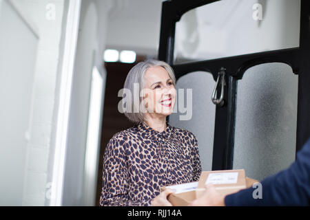 Reife Frau, die eine Lieferung nach Hause Stockfoto