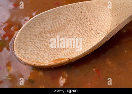 Chicken Tortilla Soup mit einem hölzernen Löffel auf das Essen mit natürlichem Licht beleuchtet. Stockfoto