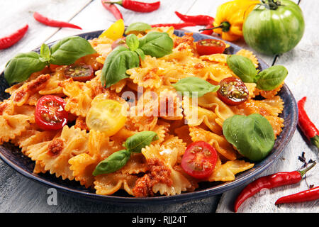 Farfalle. Köstliche cremige Italienische Penne Pasta Starter mit Pfeffer würzen und frischem Basilikum von oben gesehen auf rustikalen. Stockfoto