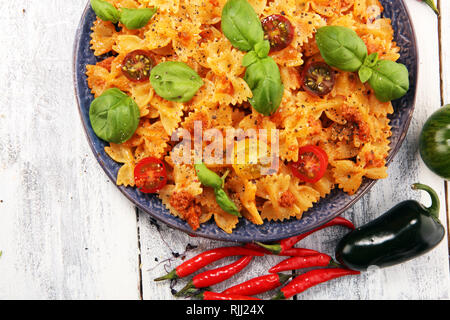 Farfalle. Köstliche cremige Italienische Penne Pasta Starter mit Pfeffer würzen und frischem Basilikum von oben gesehen auf rustikalen. Stockfoto