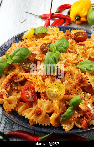 Farfalle. Köstliche cremige Italienische Penne Pasta Starter mit Pfeffer würzen und frischem Basilikum von oben gesehen auf rustikalen. Stockfoto